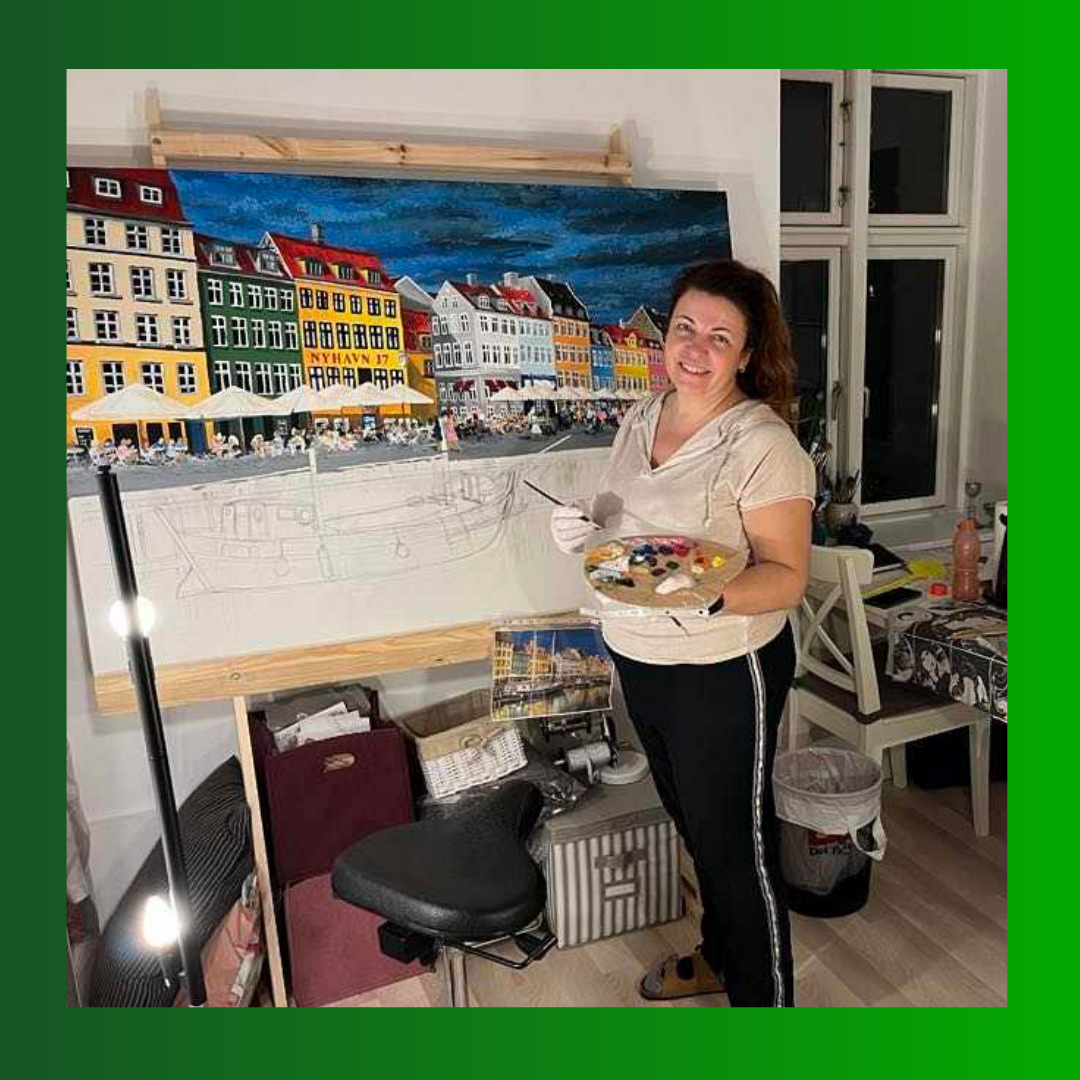 Nyhavn males. Her maler Anni, indehaver af Artistry Lounge, glad videre på sit maleri af Nyhavn i København. Billedet viser Anni, indehaver af Artistry Lounge, der glad maler videre en sen aftenstund på sit maleri af Nyhavn i København. Billedet illustrerer hvor glad man bliver af, at have styr på sin farveteori og kan få sine ønker til at lykkes i sit udtryk på maleriet.